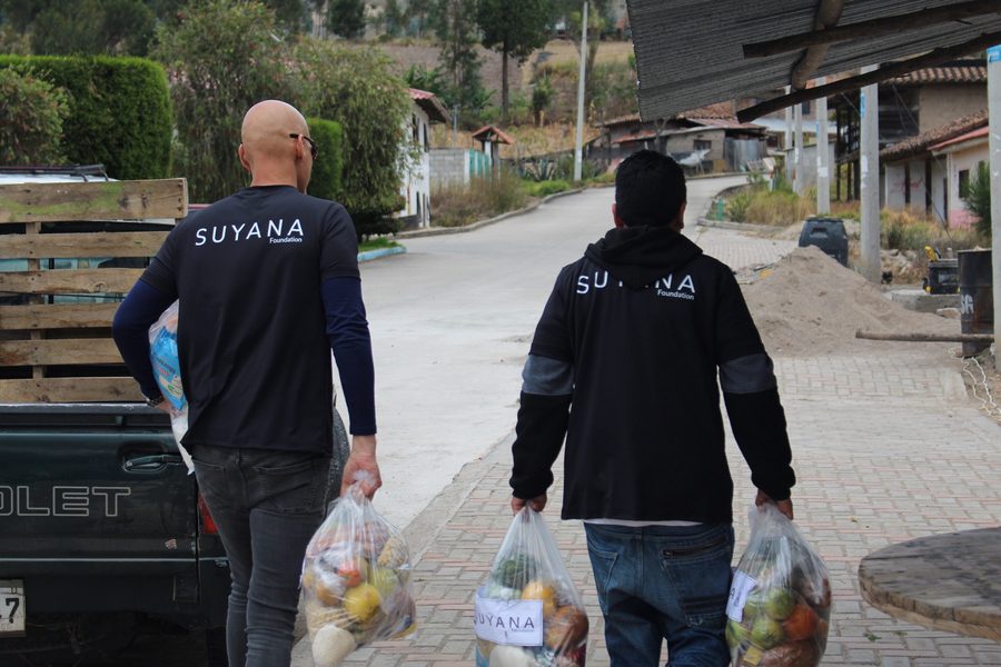 Madres y niños de una comunidad recibiendo ayuda de Suyana